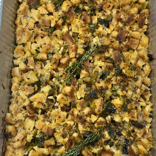 Close-up of Djonisi’s Greek stuffing with bread cubes, herbs, and dark green vegetables.